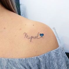 a woman with a tattoo on her shoulder that says miguell and two hearts in cursive writing