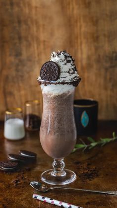 a chocolate milkshake with oreo cookies on top and whipped cream in the middle