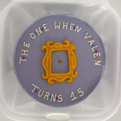 there is a purple and yellow button with the words, the one when valen turns 45