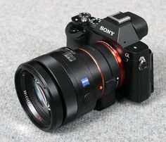 a sony camera sitting on the ground with its lens attached to it's body