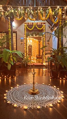 a decorated stage with candles and garlands on the floor, surrounded by greenery