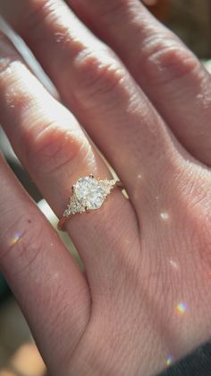 a person's hand with a diamond ring on it