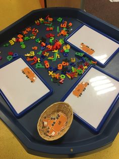 there is a tray with letters and numbers on it, next to a basket full of magnets