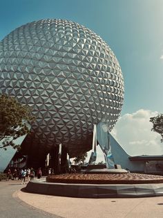 a large ball shaped building with people walking around it