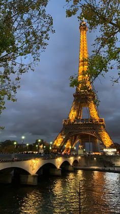 the eiffel tower is lit up at night with lights on it's sides