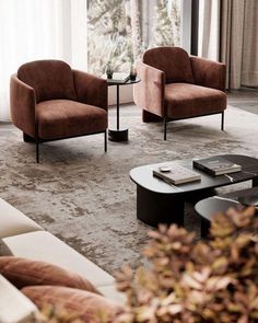 a living room with two chairs and a coffee table in front of a large window