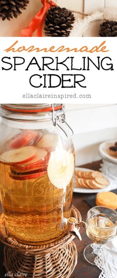 a jar filled with sparkling cider sitting on top of a table next to pine cones