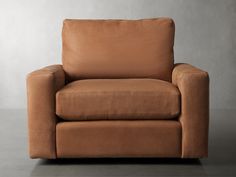 a brown leather chair sitting on top of a gray floor