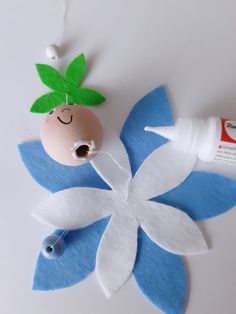 an egg sitting on top of a blue flower next to a tube of toothpaste