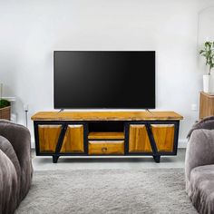 a living room with two couches and a flat screen tv on top of a wooden entertainment center