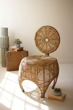 a wicker chair sitting on top of a white floor next to a potted plant