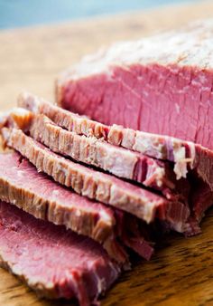 sliced meat sitting on top of a wooden cutting board