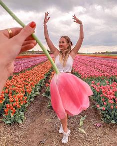 a woman in a tulip field with her hands up