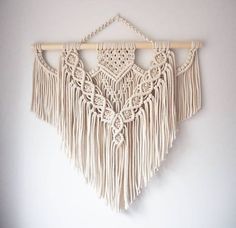 a white wall hanging with tassels and chains