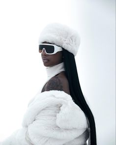 a woman with long black hair wearing sunglasses and a white fur coat is posing for the camera