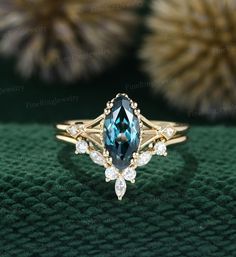 a blue topazte and diamond ring on a green surface