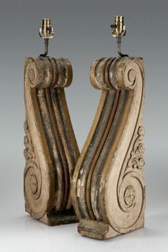 an old pair of carved wooden candlesticks with metal holders on each one side