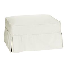 a white ottoman cover with pleated edges