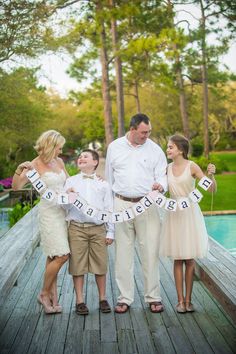 a family standing on a dock holding a banner