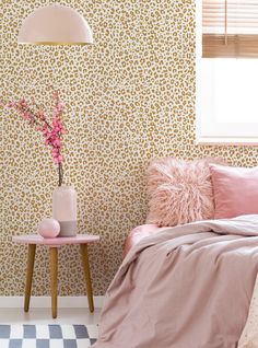 a bedroom with leopard print wallpaper and pink bedding