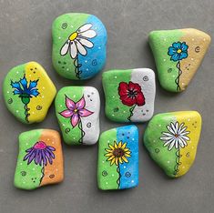 six painted rocks with flowers on them