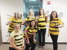 five women in bee costumes posing for a photo