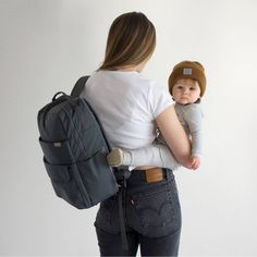 a woman holding a baby in her back pack