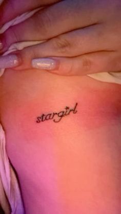 a woman's stomach with the word strength tattooed on her right side ribcage