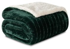 a green and white blanket sitting on top of a bed next to a black pillow