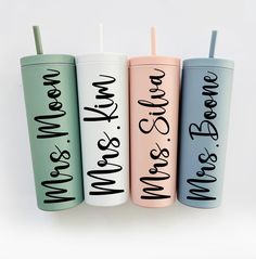 four personalized tumblers with straws in them are lined up against a white background