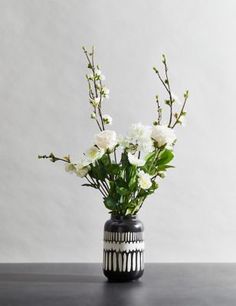 a black and white vase with flowers in it