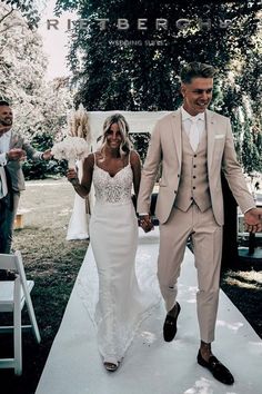 a bride and groom walking down the aisle