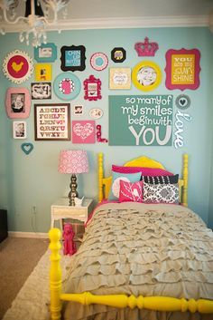 a bed room with a neatly made bed and lots of pictures on the wall above it