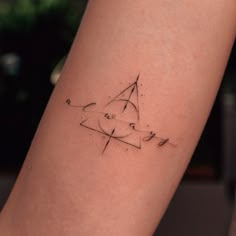 a woman's arm with a small tattoo design on the left side of her leg