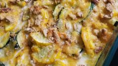 a casserole dish with zucchini, sausage and cheese on top is shown