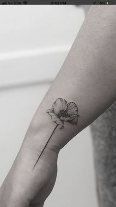 a black and white photo of a person's arm with a flower on it