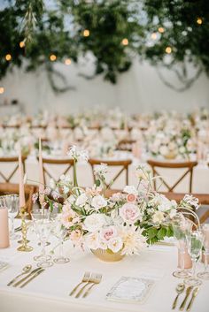 the table is set with flowers, candles and place settings for an elegant wedding reception