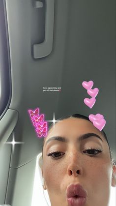 a woman sticking her tongue out in front of an airplane window with hearts on it