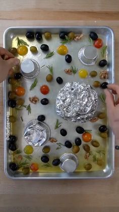 a tray with olives, tomatoes, and other food items on top of it