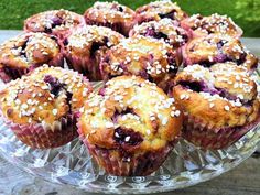 there are many blueberry muffins on the glass plate