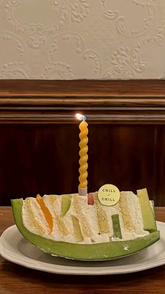 a piece of cake with a candle in it on top of a plate that is sitting on a table