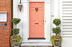 a red door with two planters in front of it