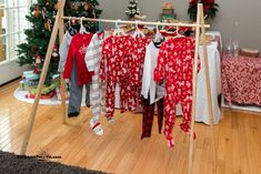 clothes are hanging on a rack in front of a christmas tree and other holiday decorations