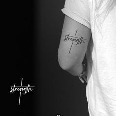 a black and white photo of a woman's arm with the word strength tattooed on it