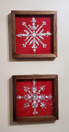 two framed snowflakes are on the wall next to each other, one red and one white