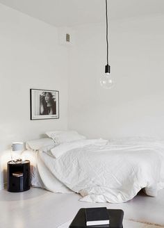 a bedroom with white furniture and pictures on the wall