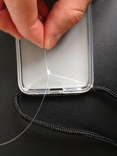 a hand is holding an electronic device with wires attached to the back of its case