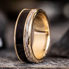 a wedding ring with antler wood and gold inlays on the inside of it