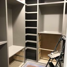 an empty walk in closet with shelves and ladders on the floor next to it