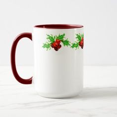 a white and red coffee mug with holly on it